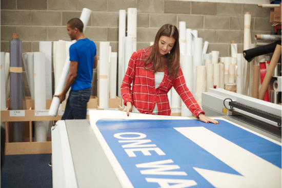 Girl working on a Vinyl Banner in a Digital printing company.