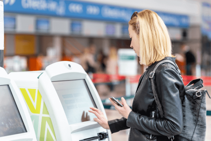Woman is navigating through digital kiosk inside the mall.