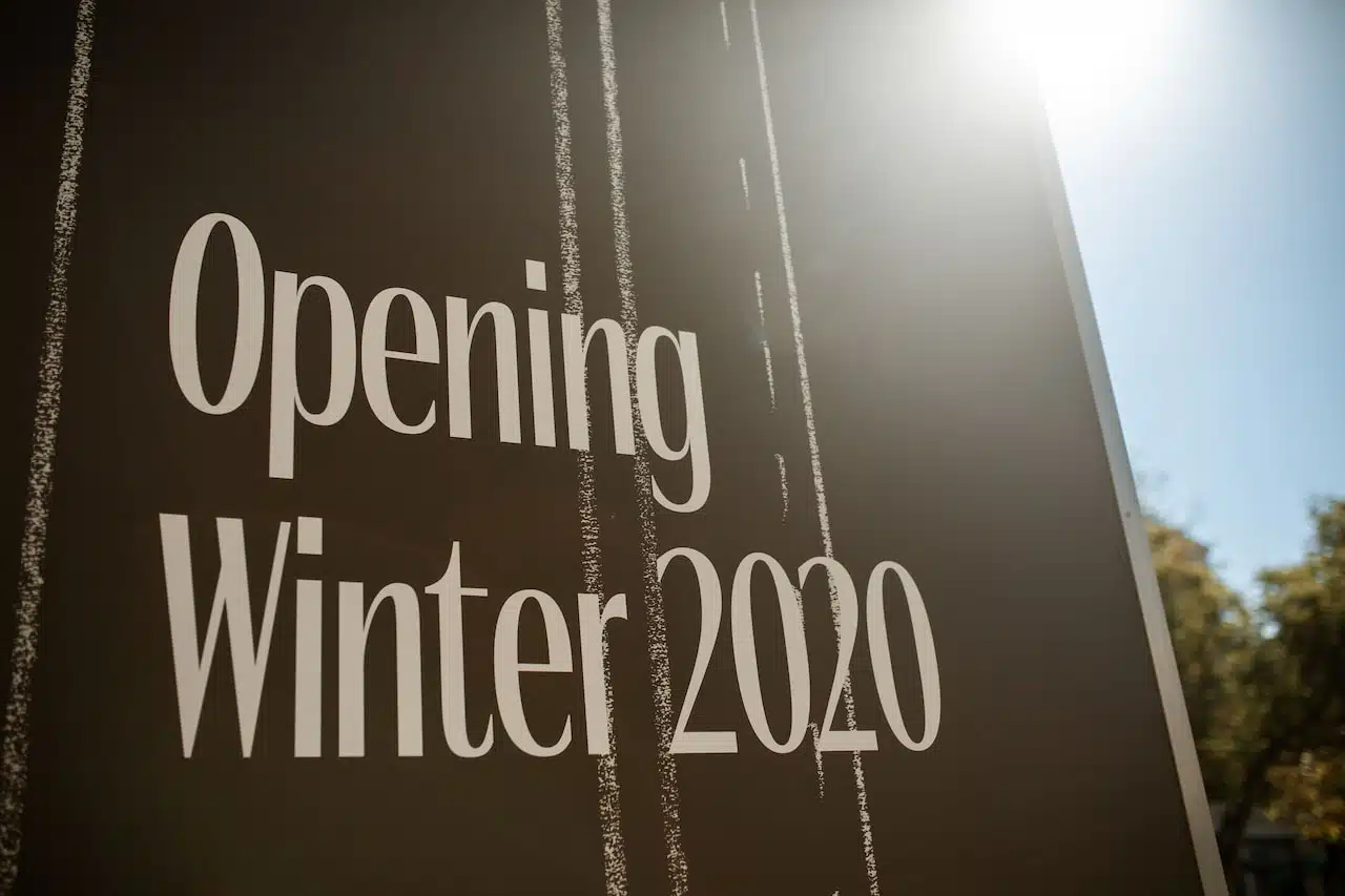 Close-up of a sign reading 'Opening Winter 2020' with sun flare
