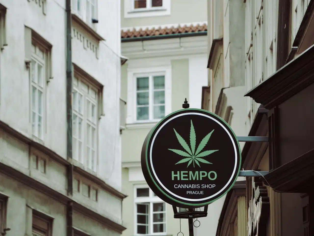 Urban scene with Hempo cannabis shop sign in Prague's historic district.