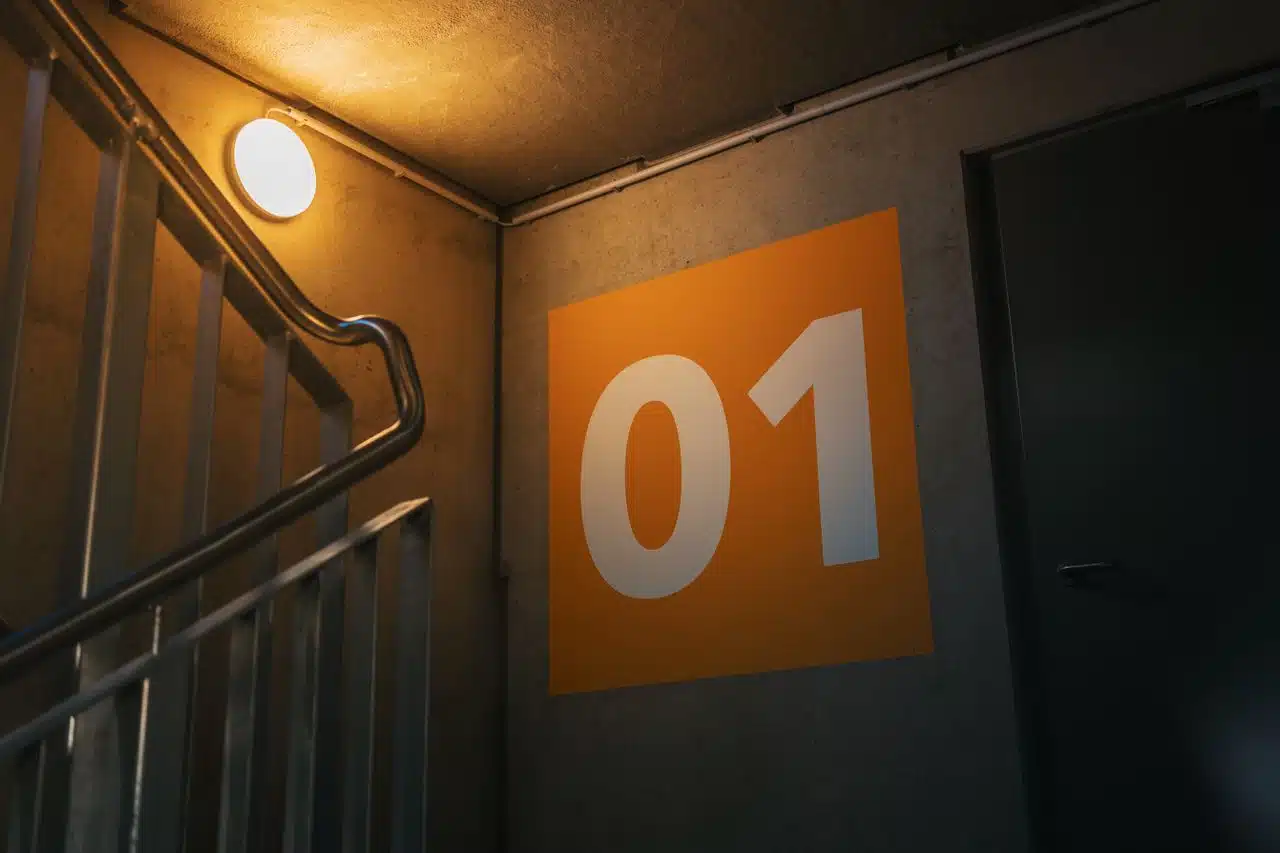 Interior wayfinding and directional signage applied to a commercial building concrete wall for navigation.