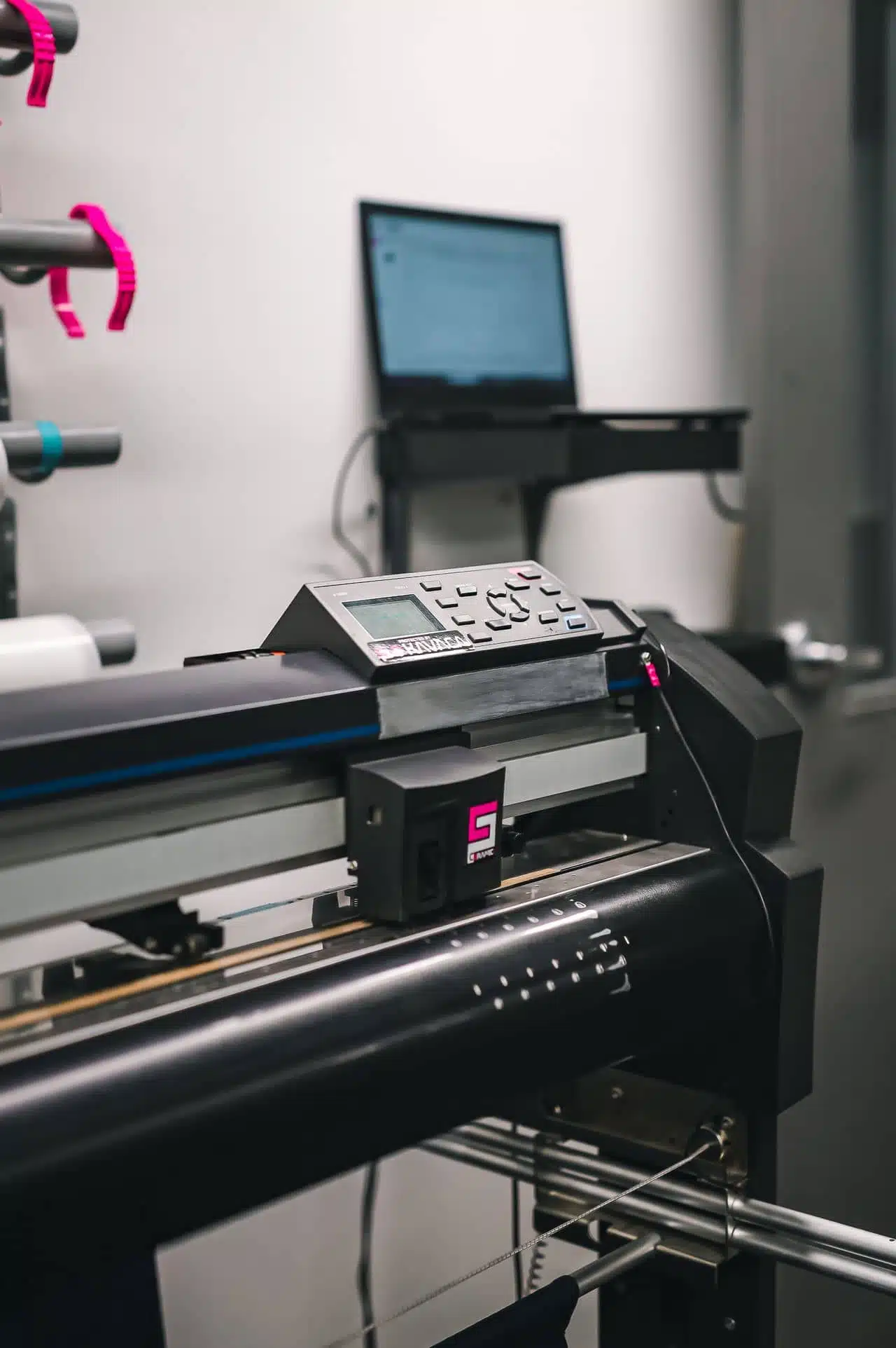 Close-up of a professional industrial vinyl plotter and cutting machine in a Denver print shop production facility.